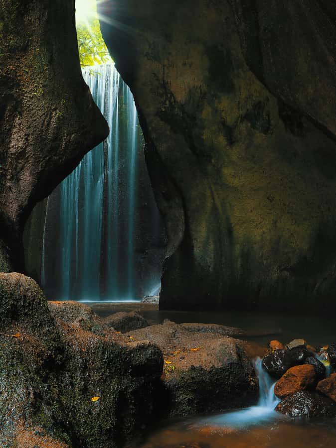 Bali: Gate of Heaven, Waterfall and Ubud All-Inclusive Tour - Tukad Cepung waterfall inside a cave, where getting wet is part of it
